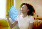 Woman fanning herself in a hot room